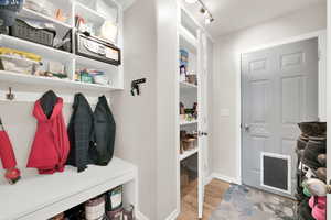 Mudroom with light wood-type flooring and baseboards