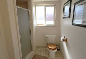 Bathroom featuring a stall shower and light flooring