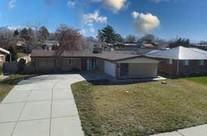 Single story home with a front lawn, concrete driveway, a garage, and a residential view