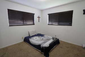 Carpeted bedroom featuring baseboards
