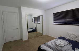 Bedroom with light carpet and a closet