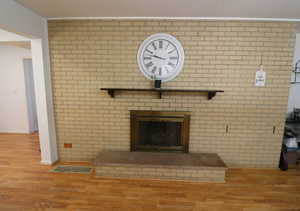 Detailed view of wood finished floors and a brick fireplace