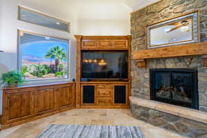 Living room with stone tile flooring and a fireplace