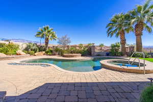 Relaxing pool / spa with a fenced backyard, a patio, and a mountain view