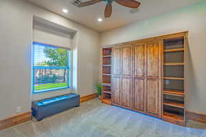 Unfurnished room featuring a textured wall, light carpet, a ceiling fan, and recessed lighting