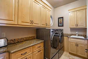 Laundry area featuring separate washer and dryer and cabinet space