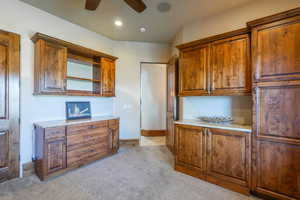 Kitchen featuring light carpet, ceiling fan, open shelves, wood finish cabinetry, and recessed lighting