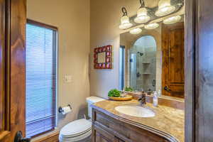 Bathroom with a textured wall, vanity, a shower stall, and plenty of natural light