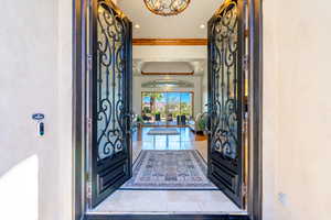 Entrance foyer with recessed lighting, a raised ceiling, and ornamental molding