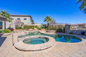 Combined pool / hot tub with a fenced backyard, a patio, and a mountain view