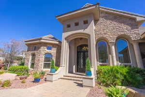 View of exterior entry with stone siding and stucco siding
