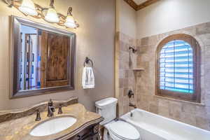 Full bathroom featuring vanity, a textured wall, shower / tub combination, and ornamental molding
