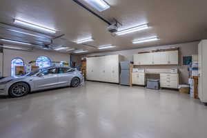 Garage featuring freestanding refrigerator and a garage door opener