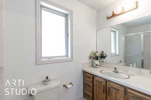 Bathroom featuring a shower stall and vanity