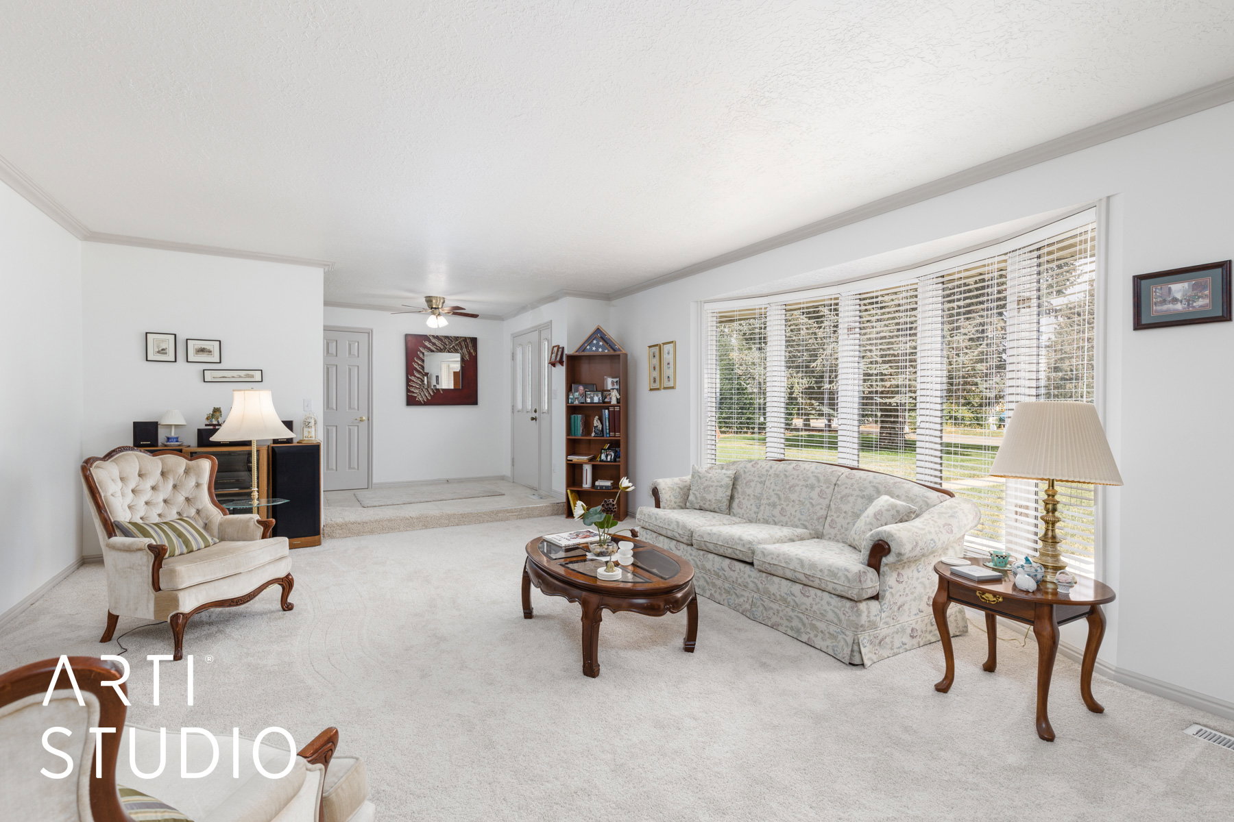 Formal living area with ornamental molding and a ceiling fan