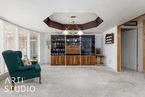 Formal dining area featuring a tray ceiling, carpet floors, and a textured ceiling