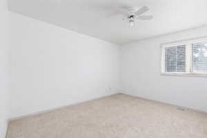 Unfurnished bedroom with carpet and a ceiling fan
