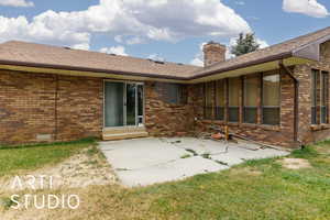 Back of house with a patio area off of Primary bedroom, a chimney, crawl space, and brick siding