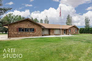 Single story home featuring brick siding and a front yard