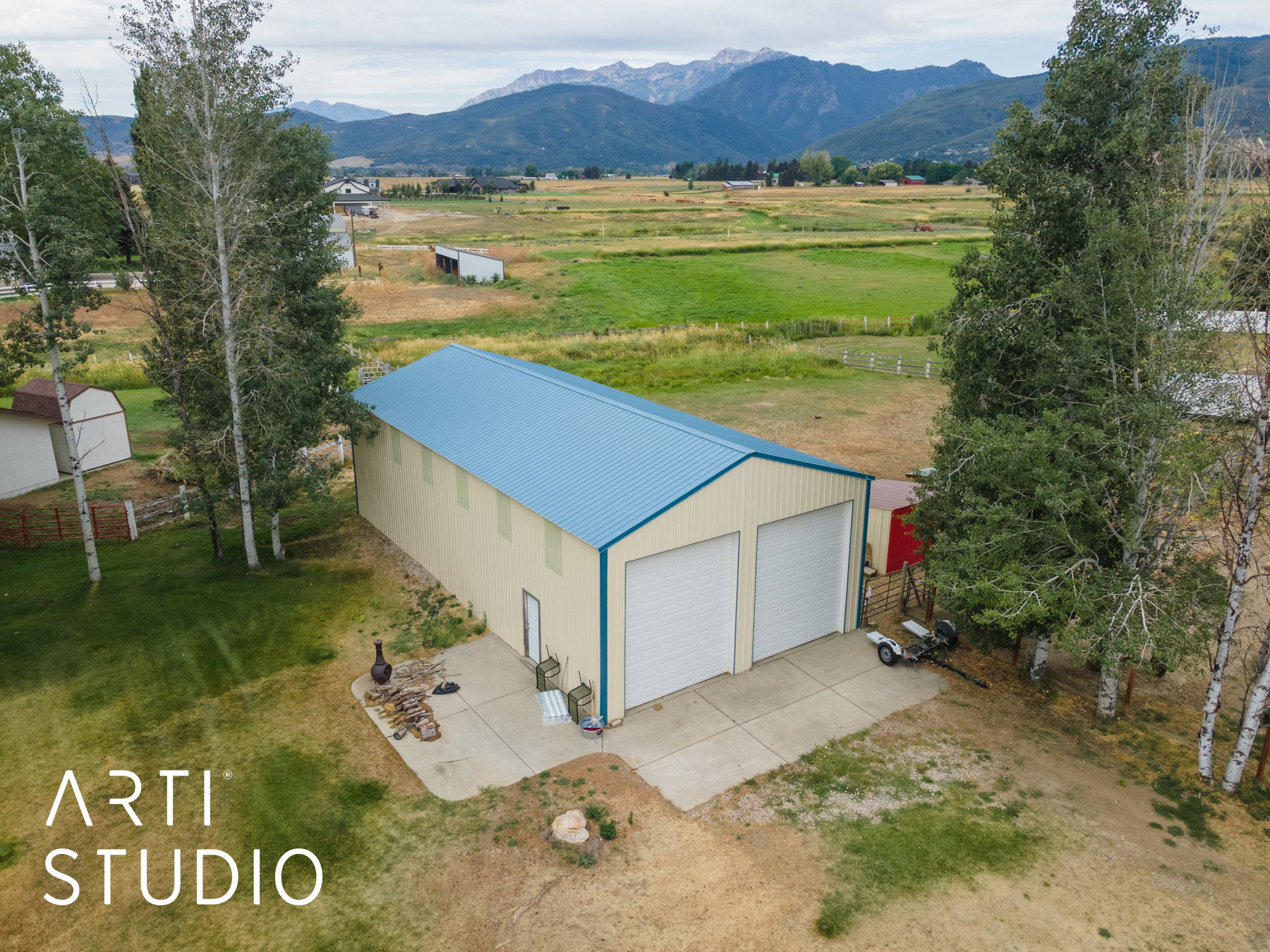 Aerial view of sparsely populated area featuring a pastoral area and a mountainous background
