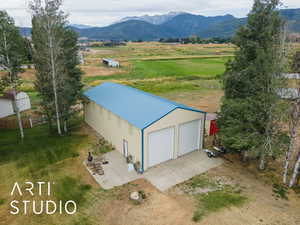 Aerial view of sparsely populated area featuring a pastoral area and a mountainous background