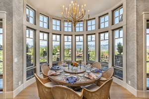 Sunroom featuring a high ceiling, suspended lighting, hardwood / wood-style floors, and wallpapered walls