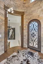 Foyer featuring wood finished floors and arched walkways