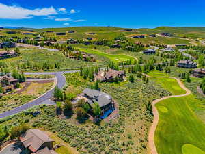 Aerial perspective of suburban area with a local golf course and a mountain backdrop