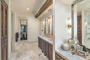 Bathroom with double vanity, vaulted ceiling, a spacious closet, recessed lighting, and a shower