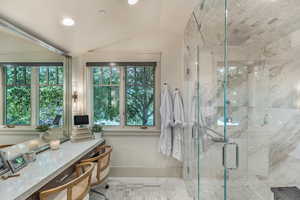 Full bathroom featuring a marble finish shower, vanity, lofted ceiling, and recessed lighting