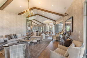 Living area featuring wallpapered walls, a chandelier, hardwood / wood-style floors, and an accent wall