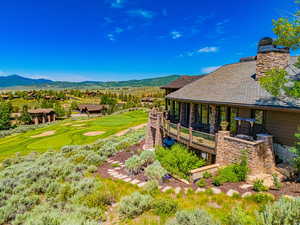 View of yard featuring view of golf course and a deck with mountain view