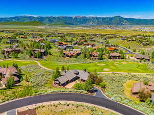 Aerial view of residential area with a mountainous background and a golf course