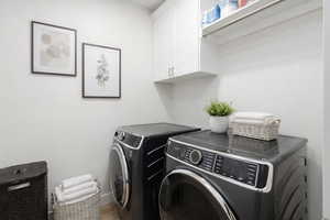 Laundry room featuring washing machine and clothes dryer and cabinet space