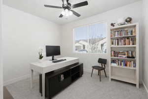 Office area featuring light carpet and a ceiling fan