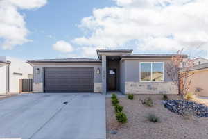 Prairie-style house with a garage, stucco siding, stone siding, concrete driveway, and a tile roof