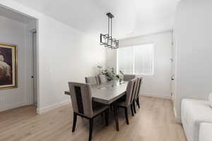 Dining area featuring light wood-style flooring and a chandelier