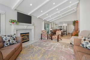 Living room featuring a premium fireplace, vaulted ceiling, and recessed lighting
