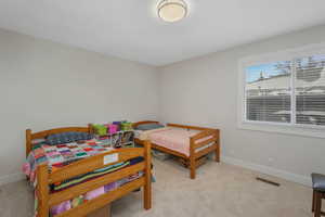 Primary ensuite Full bath with a walk in closet, double vanity, and light carpet
