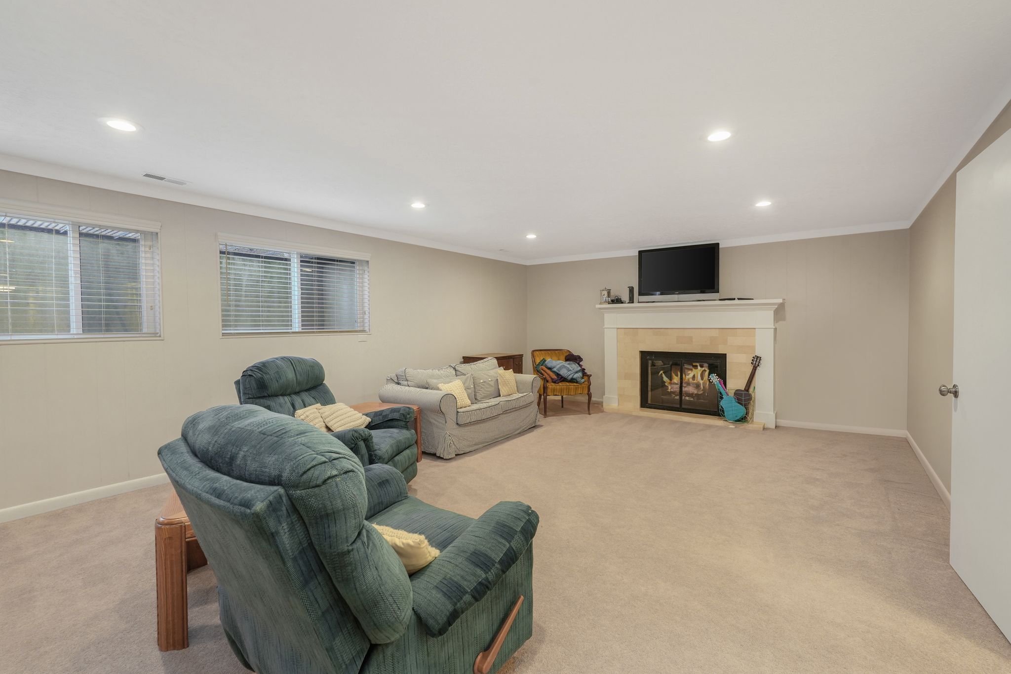Living area featuring a fireplace, vaulted ceiling, and recessed lighting