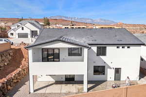Back of house featuring stucco siding and a mountain view