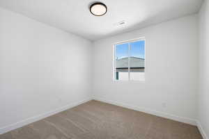 Spare room with baseboards and carpet floors