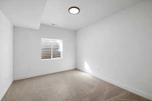 Empty room featuring light carpet and baseboards