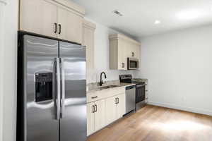 Kitchen featuring stainless steel appliances, light stone countertops, light wood-type flooring, recessed lighting, and light wood finish cabinetry