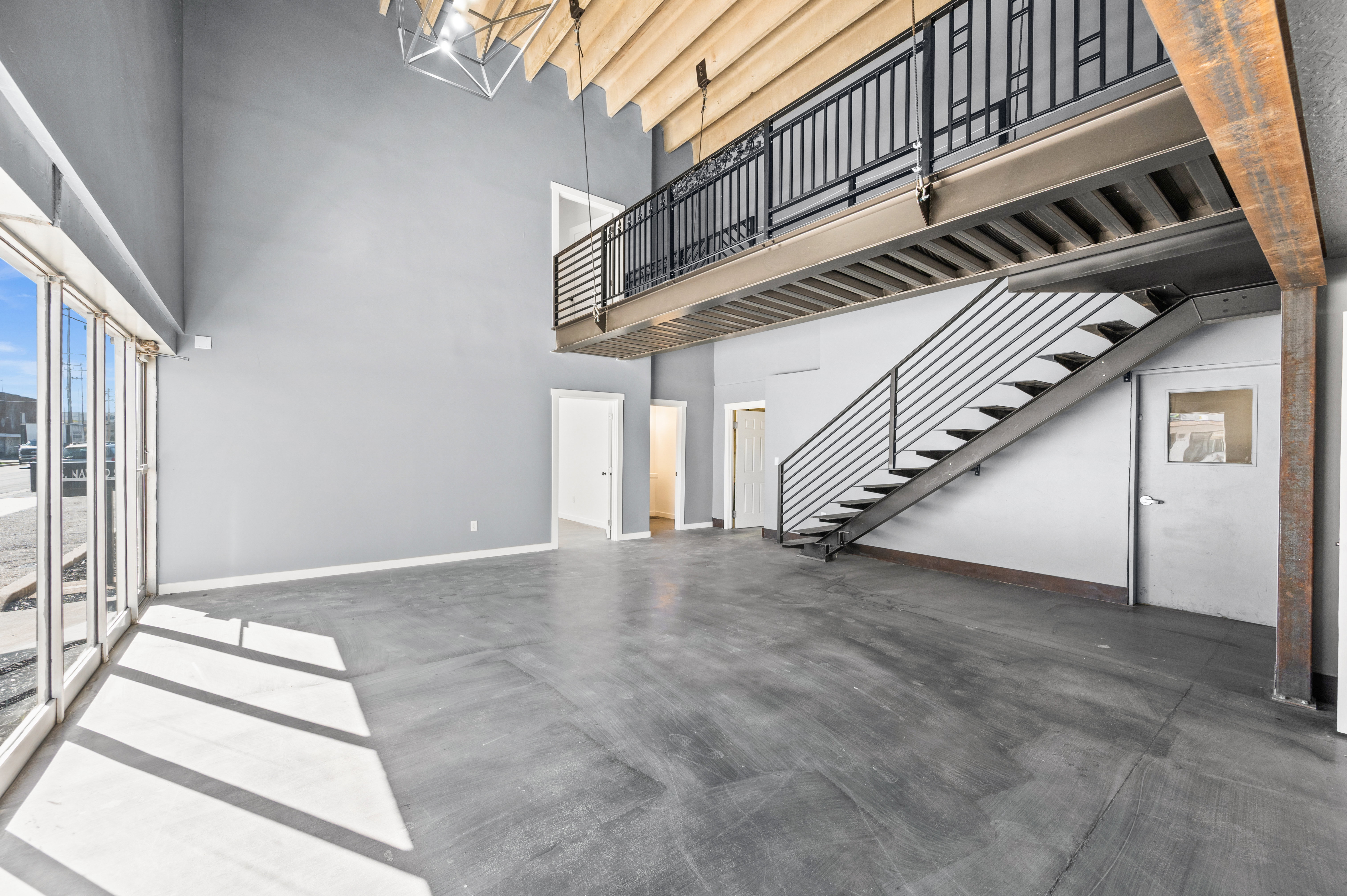 Unfurnished living room with finished concrete flooring and a high ceiling
