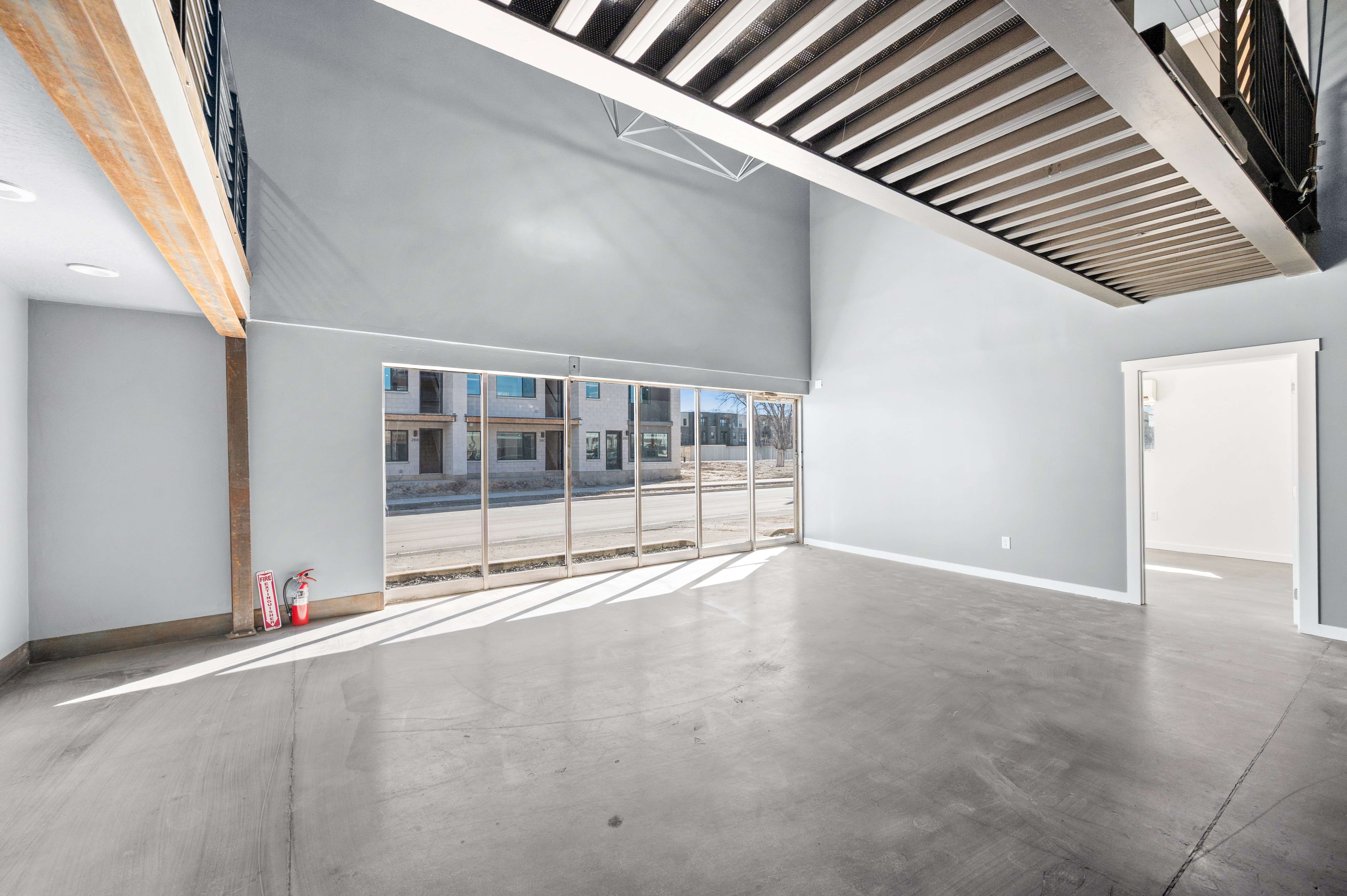 Unfurnished room with concrete flooring and a high ceiling