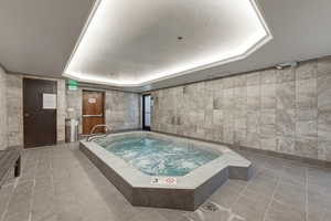 View of pool with a hot tub