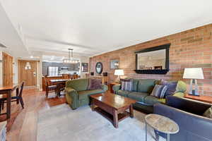 Living area featuring light wood-type flooring and brick wall