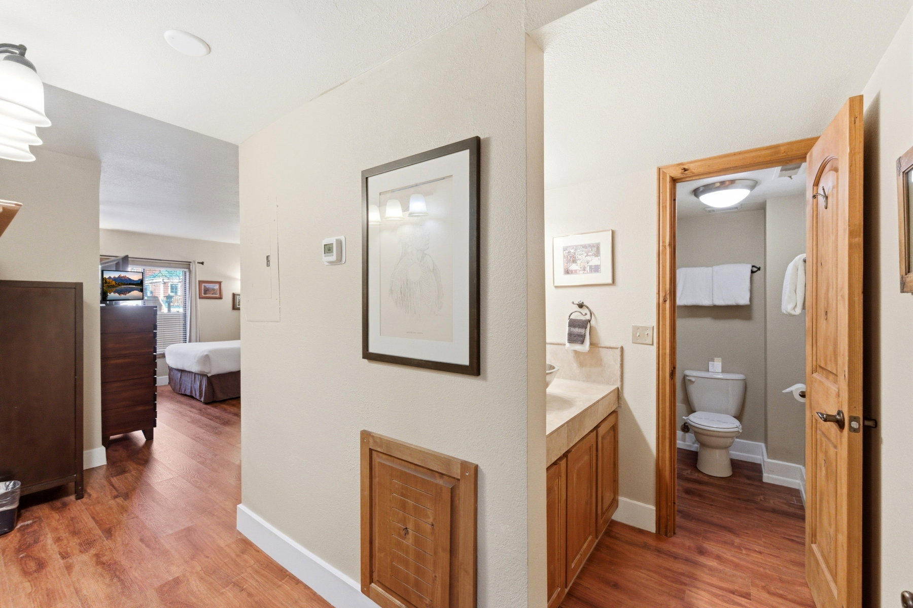 Ensuite bathroom featuring light wood-style floors and vanity
