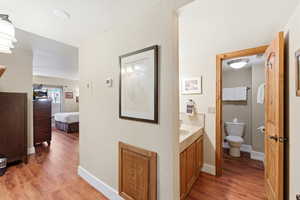 Ensuite bathroom featuring light wood-style floors and vanity